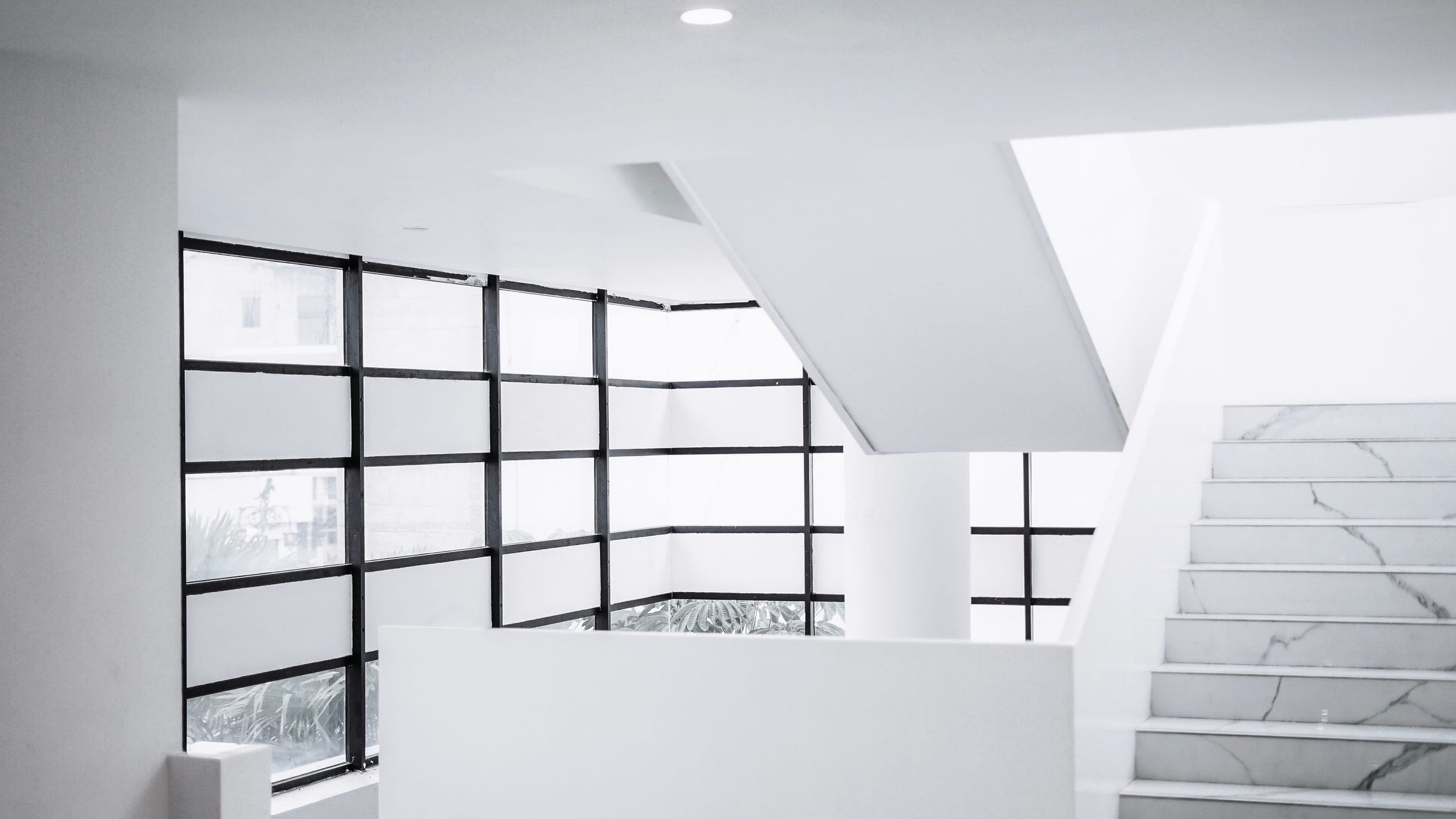 A finished interior in raking daylight, wall, ceiling, and trim meeting in clean, deliberate lines.