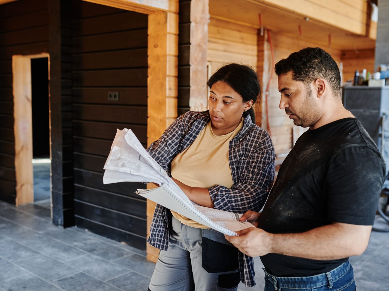 Two people reviewing project drawings together on site, the conversation rather than the camera holding their attention.