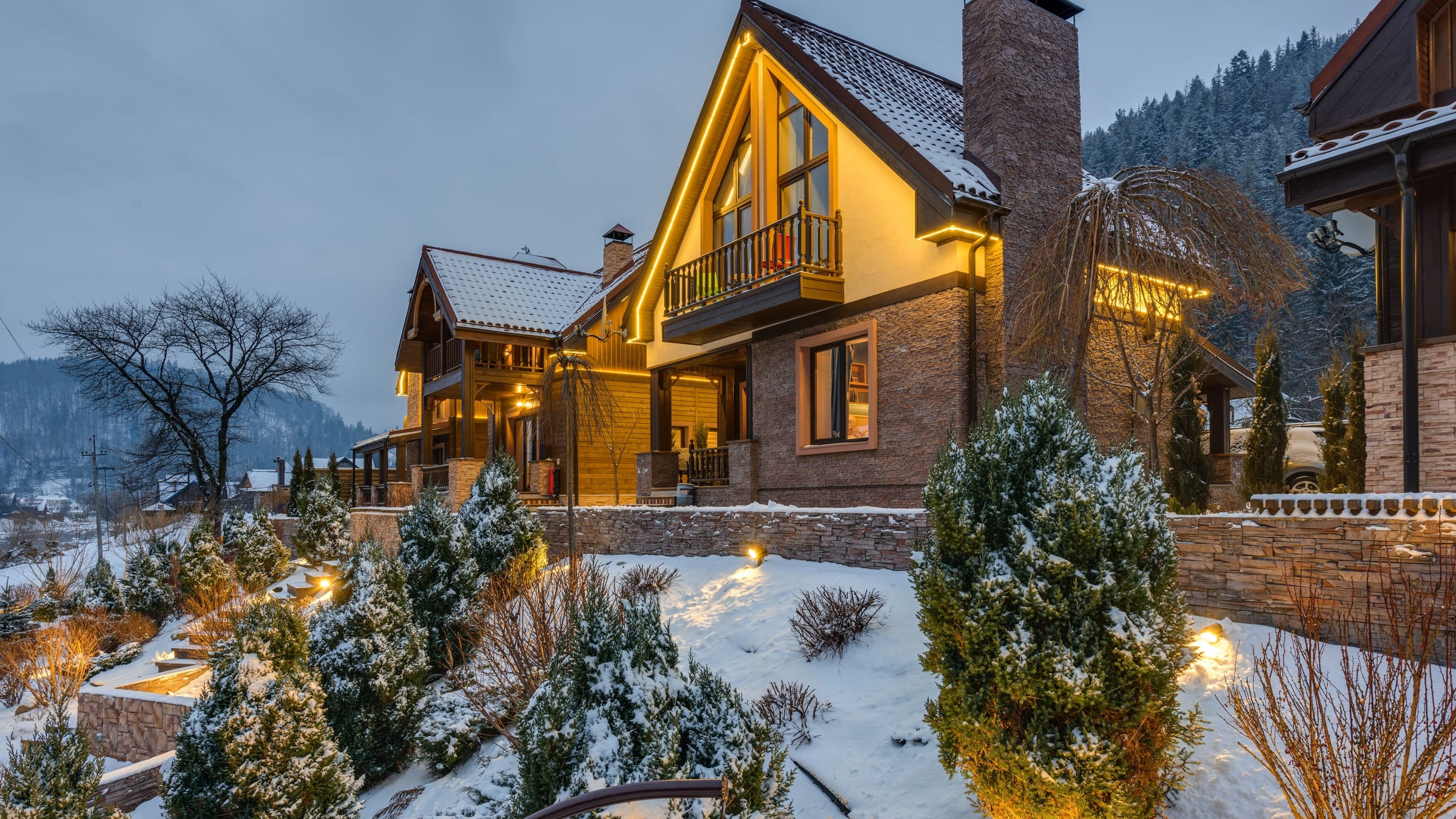 A luxury Alaska residence in warm evening light, its exterior finishes reading clean and unbroken across the elevation.