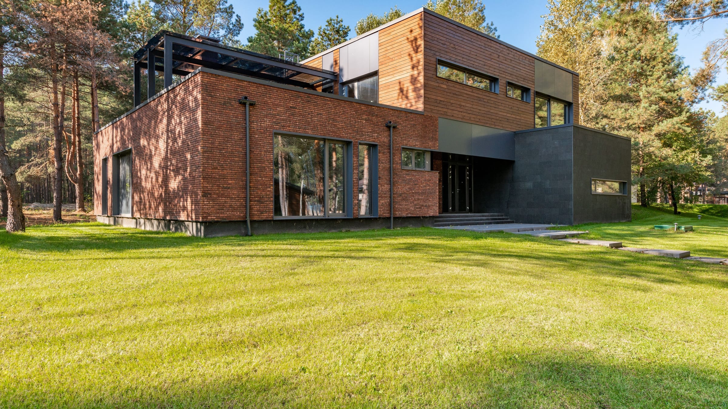 A contemporary Alaska residence in clear daylight, its exterior finishes and window trim reading crisp across the full elevation.