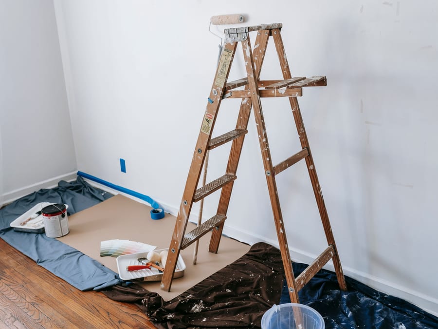 Drop cloths and masking laid carefully over floors and fixtures before painting begins.