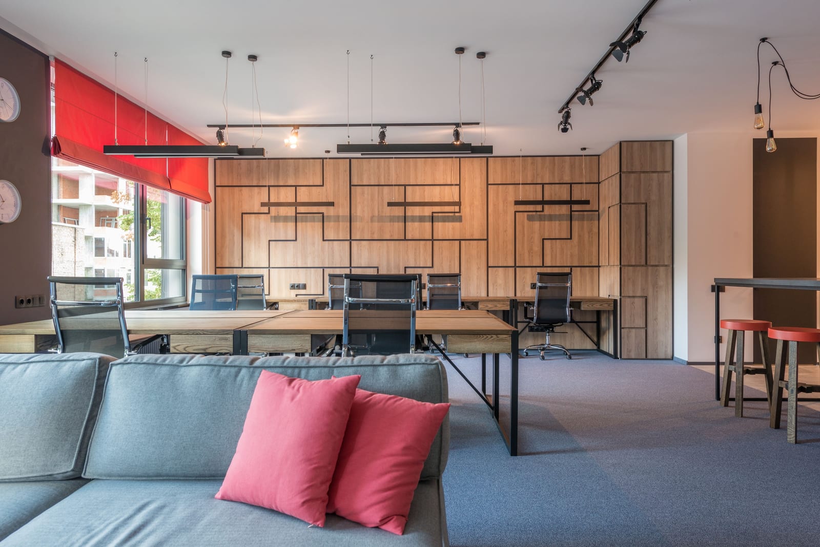 A contemporary office in daylight, its wall finishes even from the seating area through to every ceiling line.