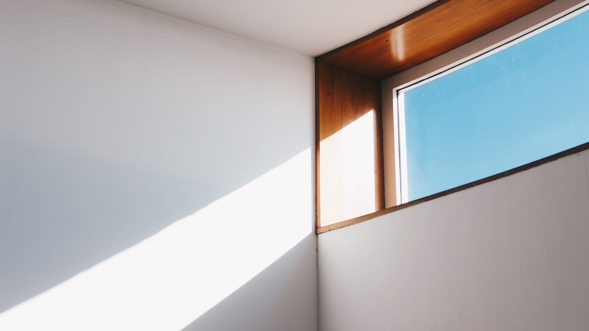 An architectural interior opening onto daylight, wall planes and trim meeting in clean, deliberate lines.