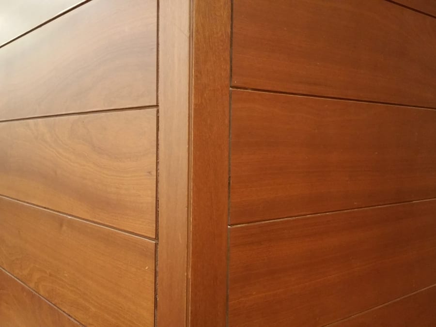 Timber panelling carrying a warm, hand-applied finish, the grain still visible through it.